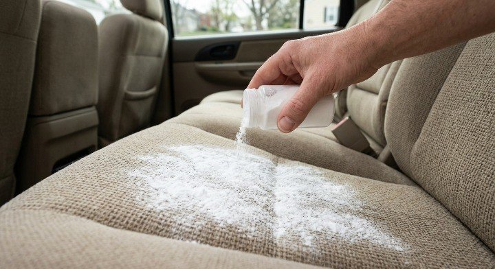 sprinkling baking soda on car seat to remove smoke odor