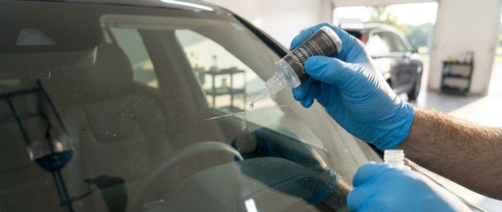 Applying acrylic scratch remover into a windshield groove