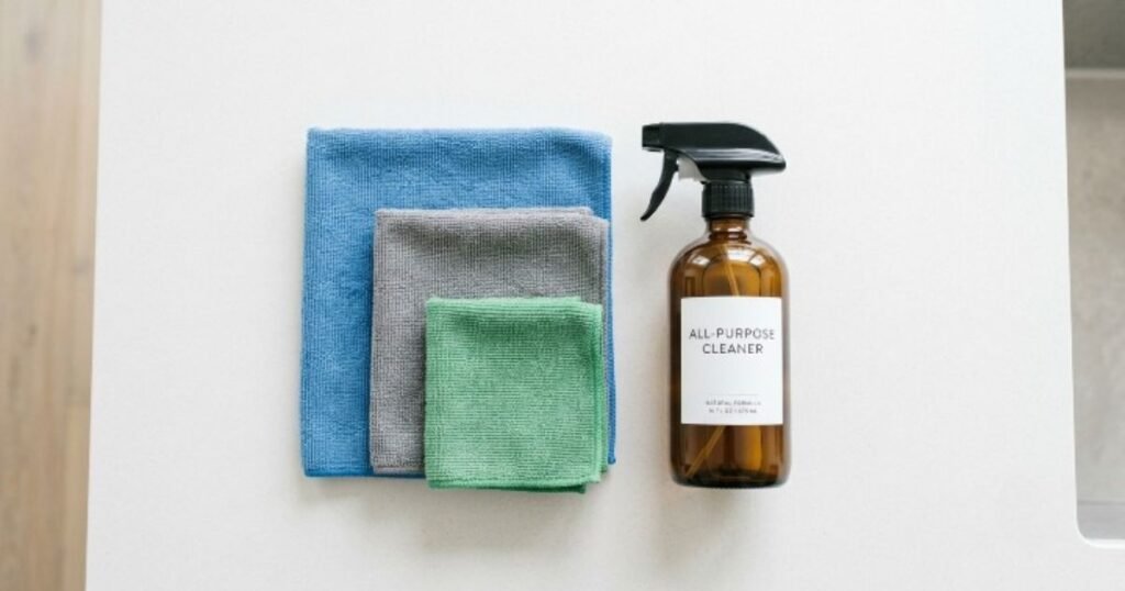 Clean folded microfiber towels and a generic spray bottle for car care contact support