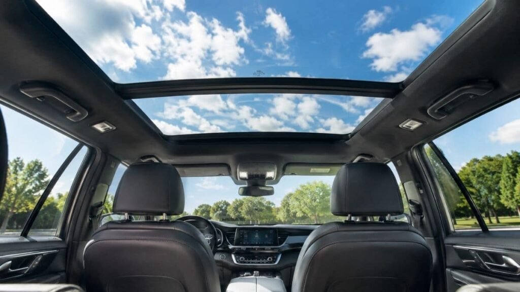 View looking up through an open panoramic sunroof inside a modern SUV